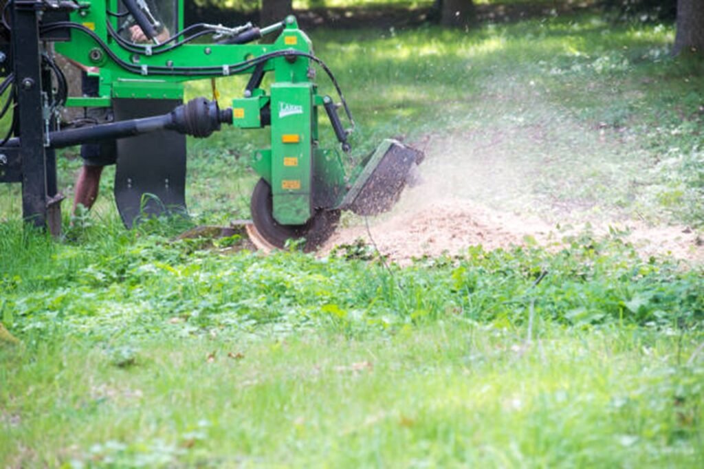 Stump grinding machine removing a tree stump and wood chips in a residential yard in Bay Village, OH